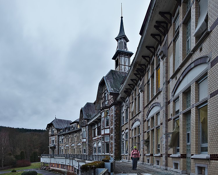 File:Sanatorium du Basil front deck looking West at a standing pink human during the evening civil twilight in Stoumont, Belgium (DSCF3602).jpg