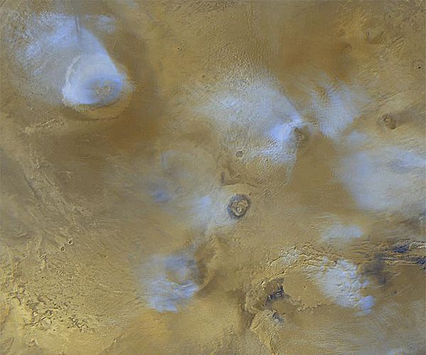 Orographic water ice clouds hover over the volcanic peaks of the central Tharsis region in this color image mosaic from Mars Global Surveyor. Olympus 