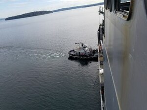 US Navy harbor tug Rainier (YT-808) assisting USNS Richard Byrd (T-AKE 4) as it moved away from the dock at Naval Magazine Indian Island.jpg