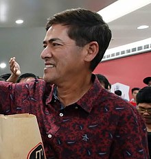 A closeup of Vic Sotto giving out shawarma.