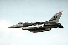 May 1992 air-to-air view of an F-16 Fighting Falcon equipped with an AGM-84 Harpoon all-weather anti-ship missile over Eglin Air Force Base. Note Air Force Systems Command badge on vertical fin.