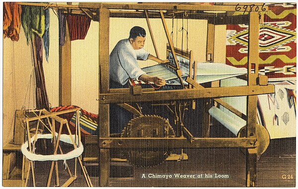 A Chimayó weaver at his loom. One clear difference between New Mexican Hispanic weaving and Navajo weaving is that Hispanic weavers stand upright whil