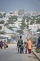 A member of the Somali Police Force walks down a road in Mogadishu with his son on December 21. AU UN IST PHOTO - Tobin Jones (11511062233).jpg
