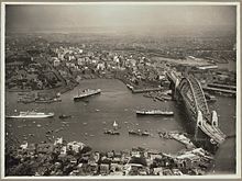 Southbound view on the day of the official opening, 19 March 1932 Aerial view of Sydney and Circular Quay on the day of the official opening of the Sydney Harbour Bridge, 19 March, 1932 (6174053762).jpg