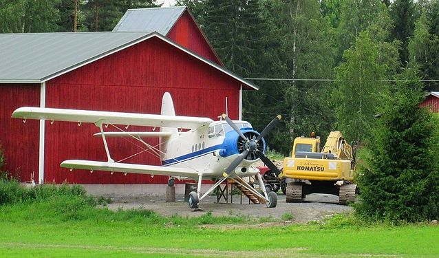 Farmyard with two tractors and … plane
