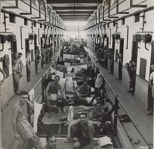 Newly liberated Allied prisoners in makeshift quarters in a central corridor and from crowded cells in Changi Prison in 1945