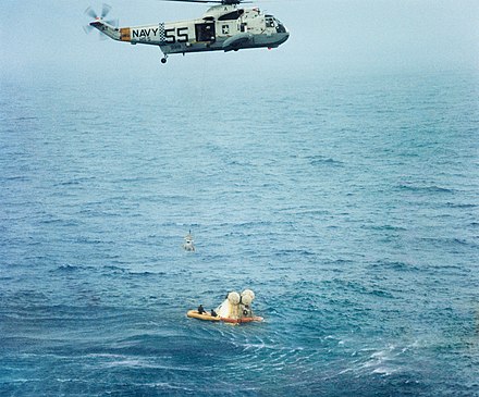 A crewmember being hoisted into the recovery helicopter