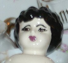 Reproduction china doll head with characteristic poorly painted appearance C.2000s American ceramic copy of antique German china doll head.jpg