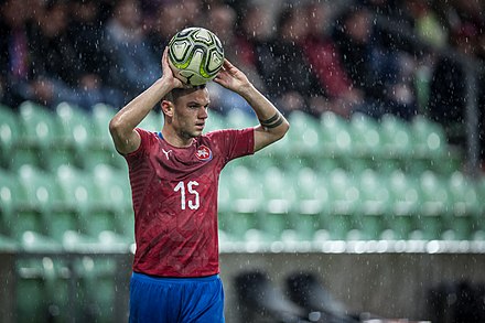 Czech defender Daniel Souček performing a throw-in after the ball was kicked out of the touch line.