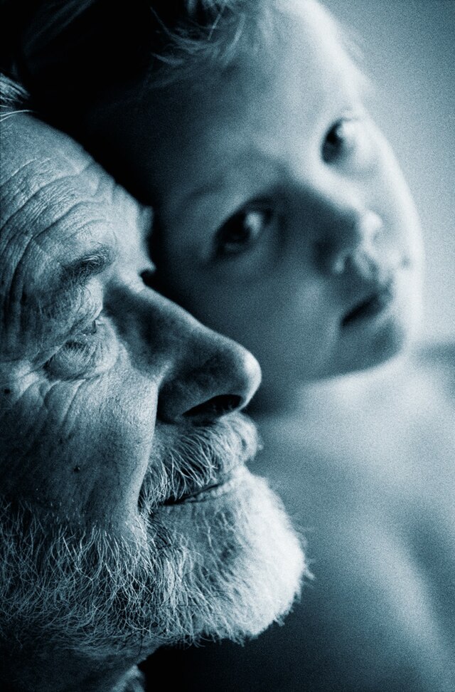 An image of an older man and young child.