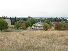 In the Historic District, looking toward Puget Sound. The visible buildings are, left to right, the Band Barracks, Guard House and Quartermasters Stables. Fort Lawton 02.jpg