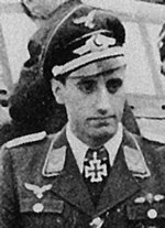 Black-and-white photograph showing a uniformed man wearing a pilot's leather jacket with fur collar, with an Iron Cross displayed at the front of his shirt collar.