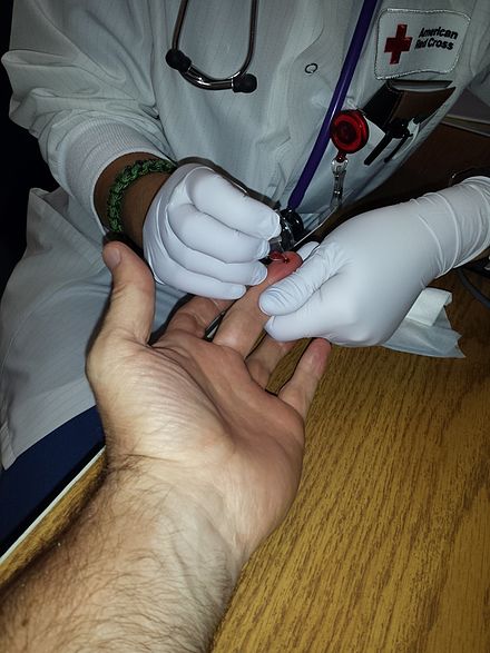 A hemoglobin concentration measurement being administered before a blood donation at the American Red Cross Boston Blood Donation Center.