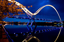 The bridge illuminated after sunset, showing
[?]
{\displaystyle \infty }
reflection Infinity Bridge in Stockton.jpg