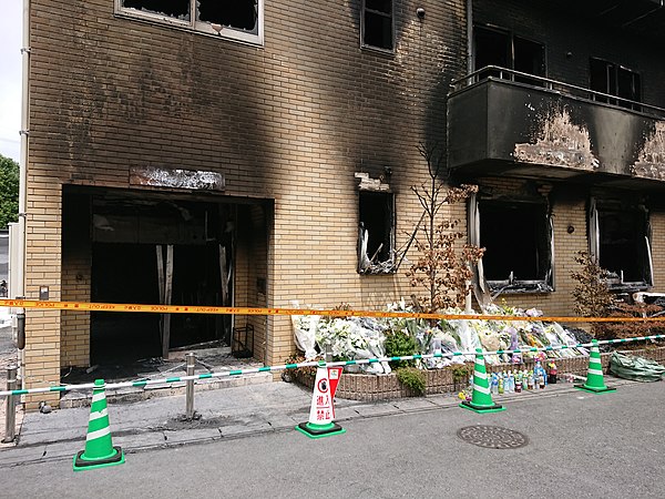 The entrance to the studio after the arson attack. Bouquets and beverages are placed in memorial.