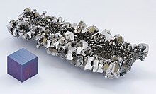 Ein Klumpen grau glänzender Kristalle mit sechseckiger Facettierung