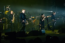 Image d'un groupe de cinq musiciens jouant sur une scène