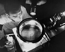 A cloud chamber detecting alpha-rays. Physicist Studying Alpha Rays GPN-2000-000381.jpg