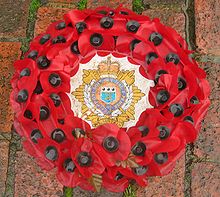 A wreath of artificial poppies featuring the Royal Logistic Corps emblem used on Remembrance Day Poppy wreath stockwell.jpg