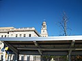 The clock tower of that building can be seen above and behind the canopy over the westbound platform.