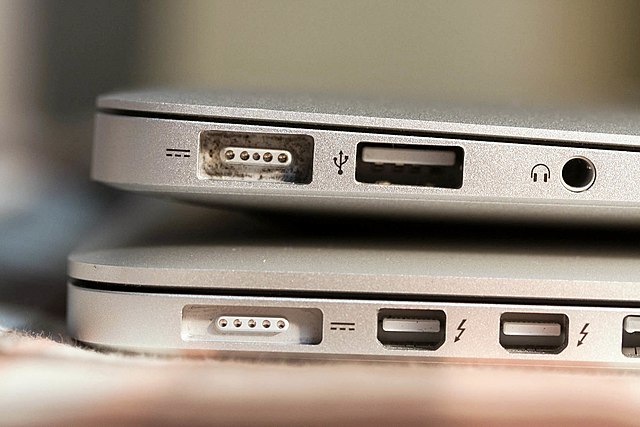 An early model MacBook Air (top) and a Retina MacBook Pro (bottom). The MacBook Pro has a thinner MagSafe 2 port and two Thunderbolt ports.