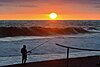 An angler and sunset on Pagak beach