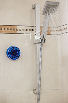 un haut-parleur de douche fixé au mur d'une douche avec une ventouse