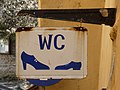 Sign in Romania, with men's and women's shoes representing gender