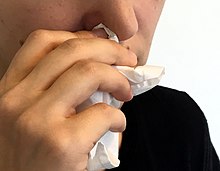 A person holding tissue to their nose. Tissue (46057881222).jpg