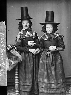 Two women in national dress drinking tea (Jones) NLW3362597.jpg