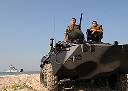 Український БТР-80 на узбережжі острова Тендра. На задньому фоні ВДК «Костянтин Ольшанський», 15 липня 2010.