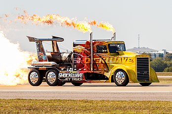 Shockwave Jet Truck movido a três motores a jato Westinghouse J34 durante o Alliance Air Show de 2014 em Fort Worth, Texas, Estados Unidos. Atualmente, detém o recorde mundial de caminhões de tamanho normal a jato com 605 quilômetros por hora. Foi dirigido pelo americano Chris Darnell, que usou o caminhão para competir contra aviões que iam a 480 quilômetros por hora em uma corrida de arrancada em shows aéreos, muitas vezes vencendo. Para desacelerar o caminhão no final de uma corrida eram necessários dois paraquedas de aeronaves. Chris Darnell morreu em uma dessas exibições, em 2 de julho de 2022, após sofrer um capotamento resultante de uma falha mecânica, que destruiu o caminhão. (definição 4 617 × 3 078)