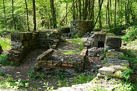 Fondations et base de murs composées de pierres et de briques de formes variées.