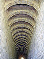 Canal du bâtiment des latrines dont les arcs délimitent l'ouverture des 60 sièges des moines à l'étage.