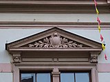 Pediment with a cartouche in it, above a double-window, in Pirna (Germany)