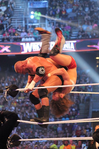 Daniel Bryan performs a sunset flip superbomb to Triple H at WrestleMania XXX.