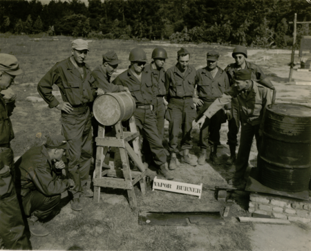 Civil Affairs Staging Area (CASA) soldiers receive training on a vapor burner. Vapor burners were used to heat water for mess kit cleaning and bathing. CASA Vapor Burner Training.PNG