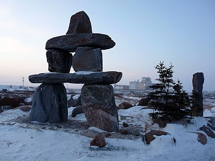 An inukshuk with the Port of Churchill behind, en route to Cape Merry