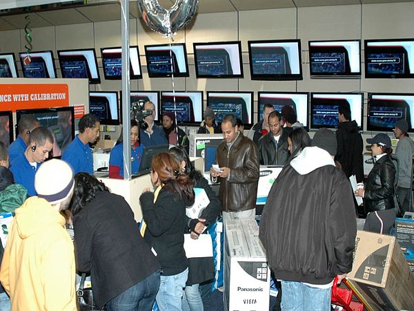 A crowd of shoppers in the flatscreen TV section of the big box consumer electronics store Best Buy