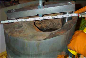 Erosion of the 6-inch-thick (150 mm) carbon steel reactor head, caused by a persistent leak of borated water, at the Davis-Besse Nuclear Power Plant. Davis-BesseHole.png