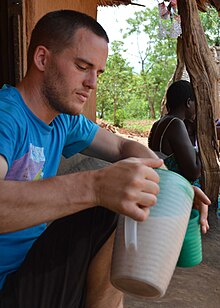 A person drinking thobwa as a guest in Malawi Drinking thobwa, Malawi.JPG