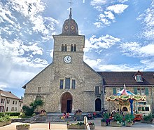 L’église Saint-Nithier avec un carrousel dans une ambiance estivale et légère.