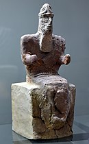 Бог Енлил, седнал. Свитият ляв юмрук държи предмет (сега изгубен). От Нипур, Ирак. 1800 – 1600 г. пр.н.е. Печена глина. Виждат се следи от червена и черна боя. Изложен в Музея-Багдад, Ирак