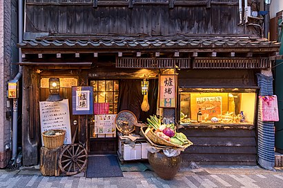 Illuminated facade of a restaurant serving traditional food with fresh vegetables in Chiyoda, Tokyo
