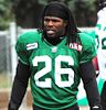 A black man with dreadlocks wearing a green jersey with the number 26 in white.