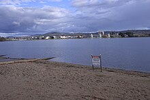 Un panneau métallique érigé sur les rives sablonneuses du lac informe de l'interdiction de l'activité aquatique en raison de la pollution