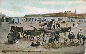 Ancienne photographie colorisée représentant un groupe d'enfants sur une plage