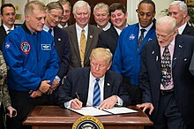 President Trump signs an executive order re-establishing the National Space Council, with astronauts Dave Wolf and Al Drew, and Apollo 11 astronaut Buzz Aldrin (left-to-right) looking on. National Space Council Executive Order (NHQ201706300004).jpg