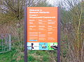 Visitor centre sign outside car park in English and Welsh