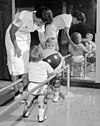 Seorang anak yang menderita polio menerima fisioterapi pada tahun 1950-an